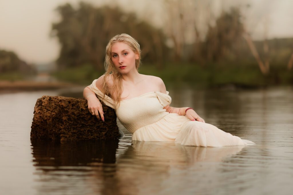 The Essence of Luxury Photography- female laying in the water during a senior portrait session