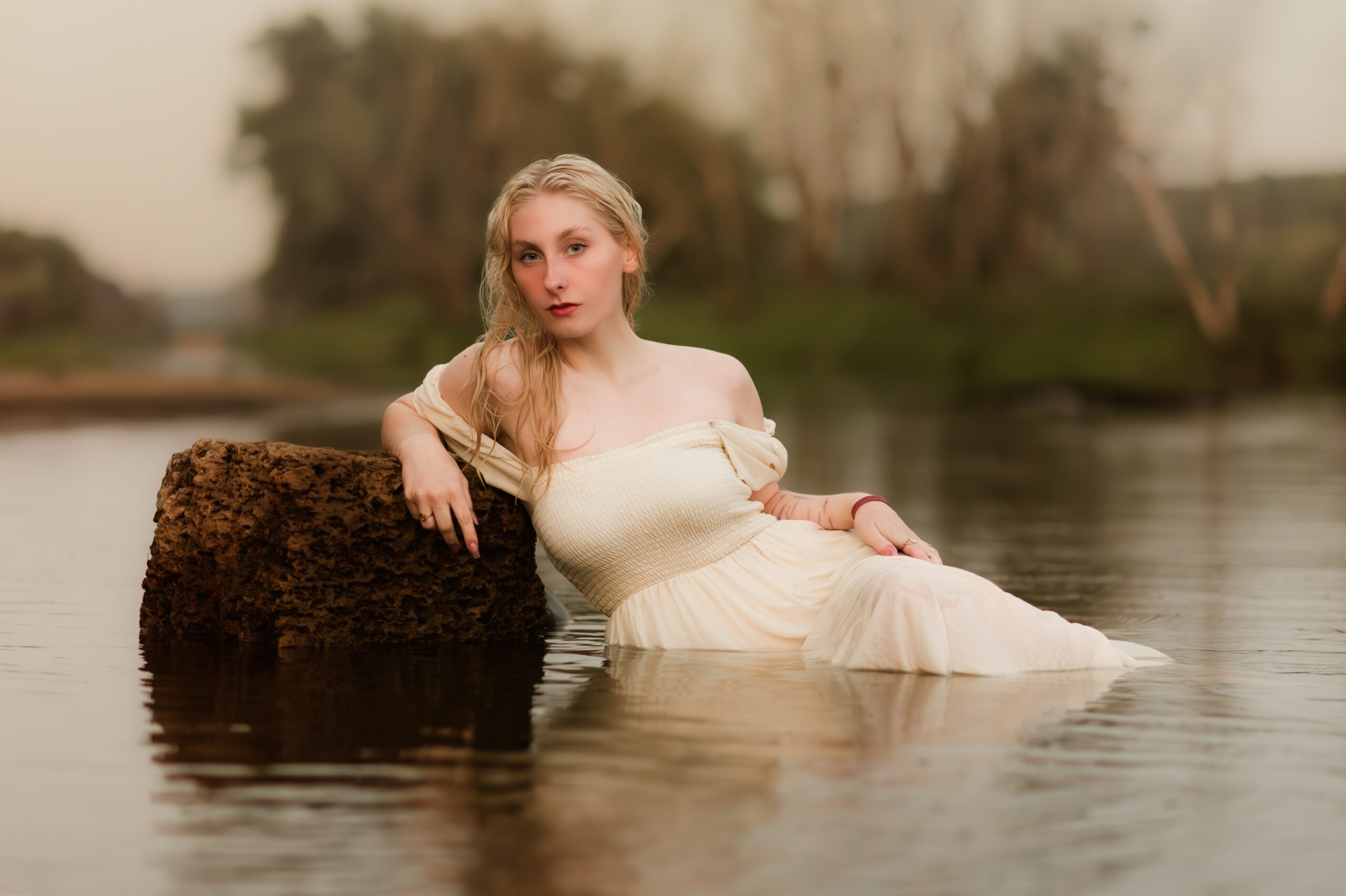 female laying in the water during a senior portrait session