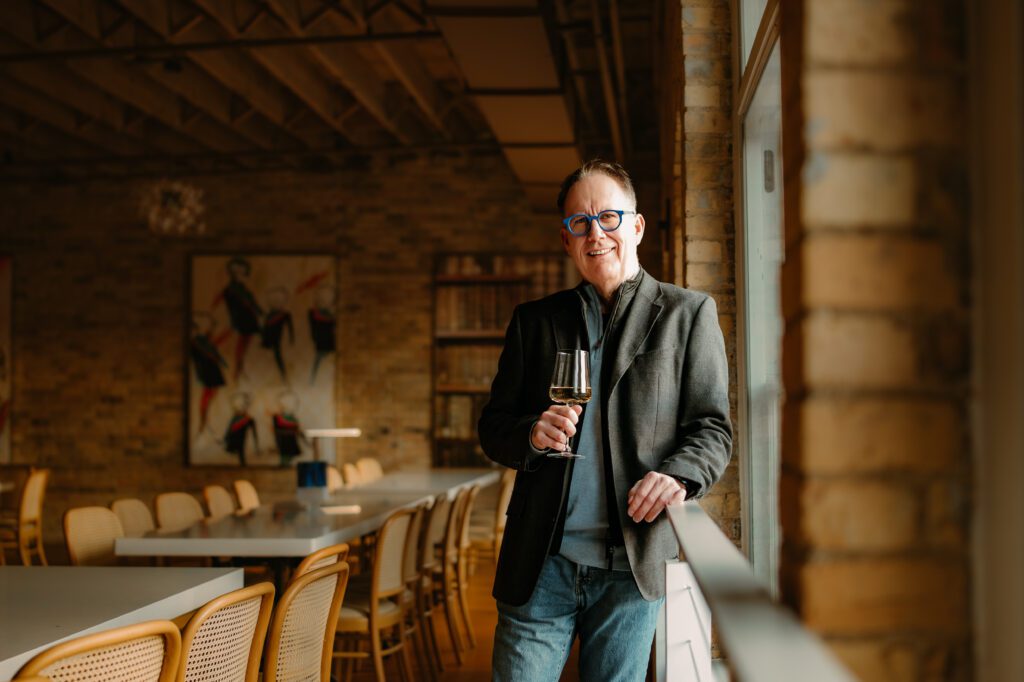 Man standing near a window at Maison Margaux in North Loop drinking wine.Navigating Love: Transform Your Dating Profile with Professional Photos in the Twin Cities, MN
