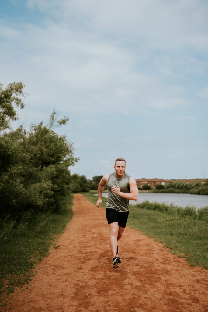 Brandon running outdoors along a river trail, showing an active and confident lifestyle.